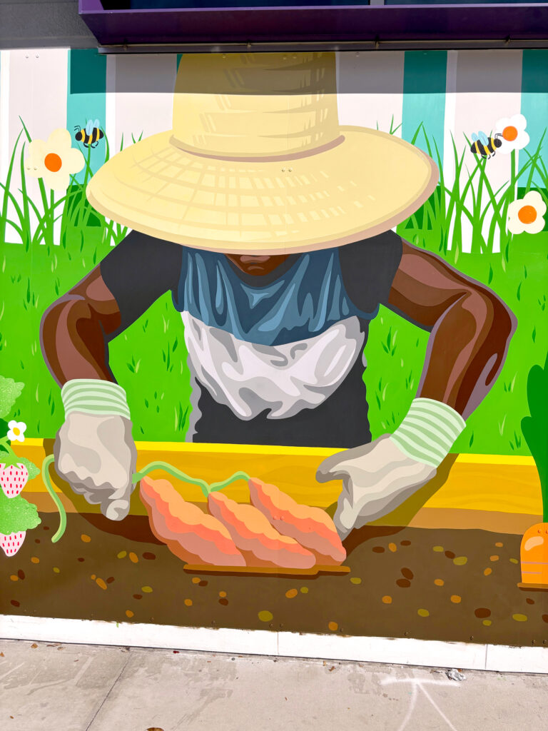 SKIP A Pivotal Character Artworks Painting Sign community garden bloomberg foundation art pollination festival orlando city soccer stadium Hand Painted muralist downtown Florida Orlando Signage Mural Logo diversity sports wall parramore district sustainability bees